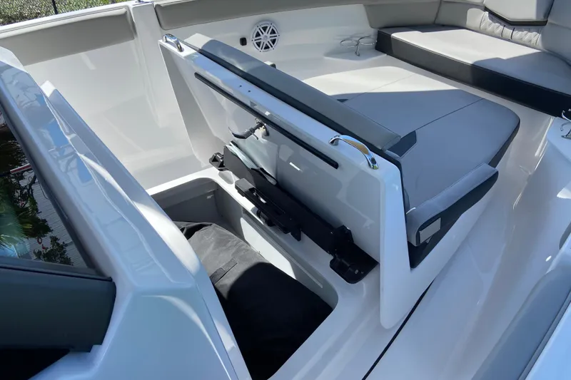 Slide: The Image of 2026 Monterey Elite 25 OB boat interior with open storage compartment and cushioned seating. - 26
