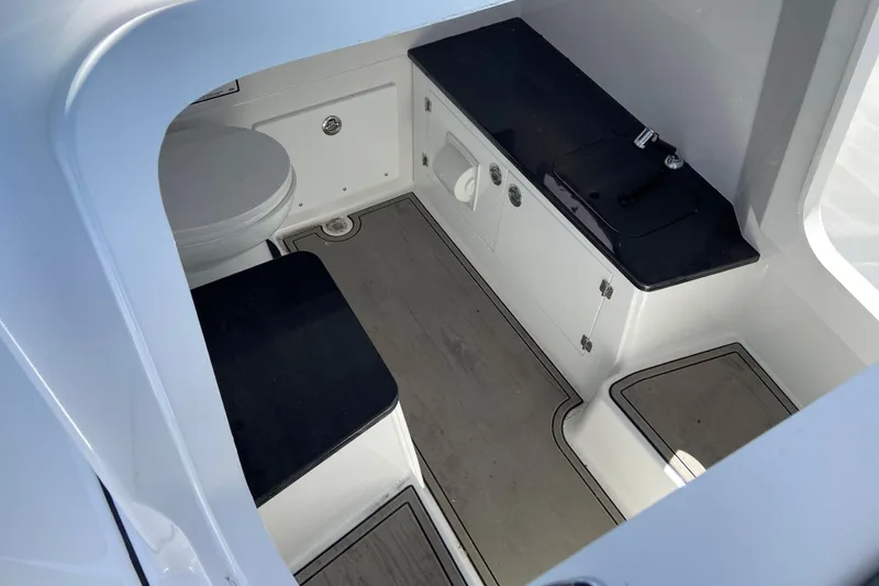 Slide: The Image of Interior of 2026 Monterey Elite 25 OB boat featuring a compact bathroom and sink area. - 27
