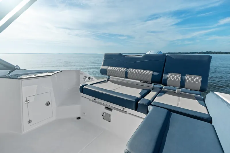 Slide: The Image of Manufacturer Provided Image: 2026 Monterey Elite 25 OB boat interior with blue and white seating, overlooking calm waters. - 3