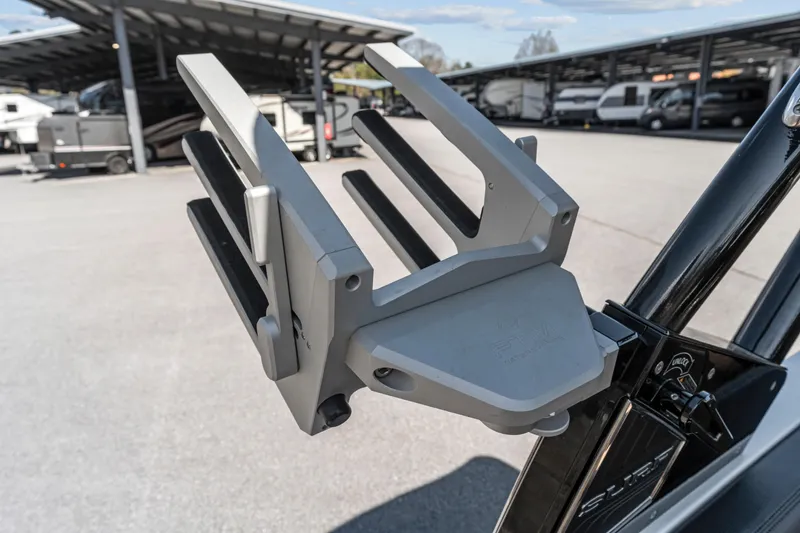 Slide: The Image of 2024 Cobalt CS23 Surf boat rack in a parking area with RVs in the background. - 13