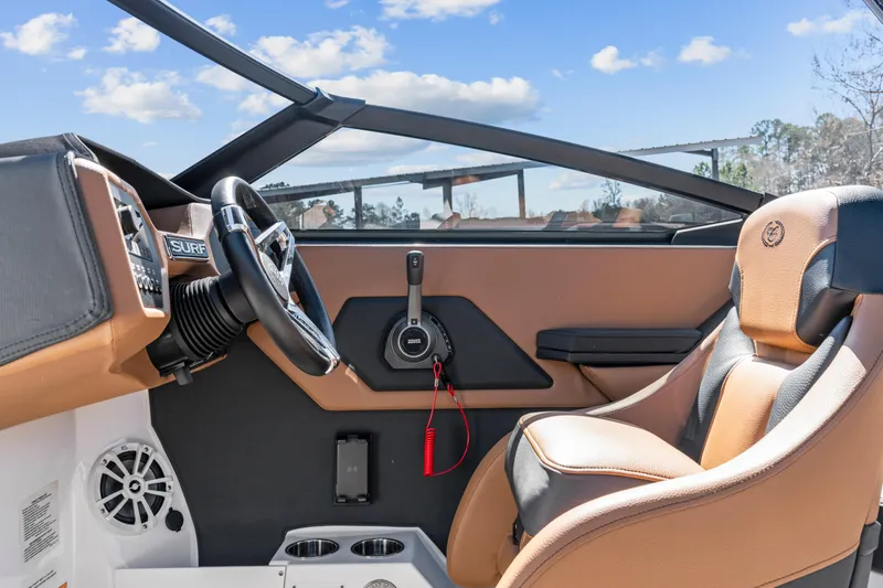 Slide: The Image of 2024 Cobalt CS23 Surf boat interior with steering wheel and tan seating. - 18