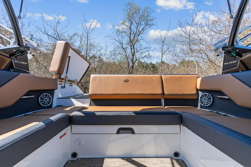 Slide: The Image of 2024 Cobalt CS23 Surf boat interior with brown seating and speaker system. - 20