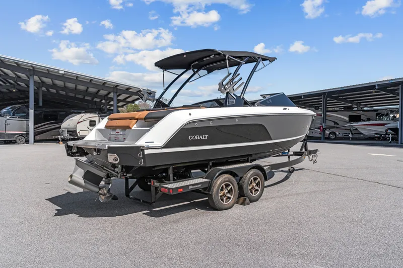 Slide: The Image of 2024 Cobalt CS23 Surf boat on trailer under blue sky. - 3