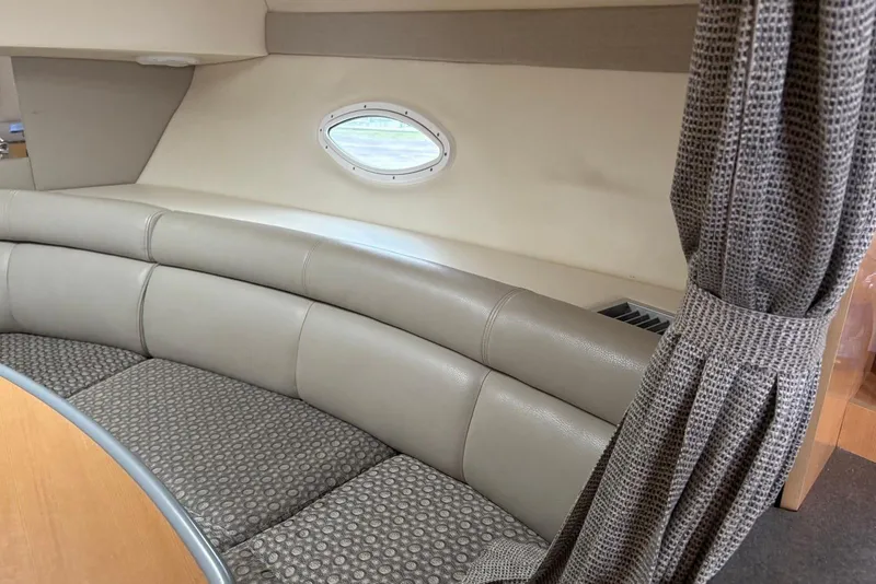 Slide: The Image of 2004 Maxum 3100 SE boat interior with curved seating and porthole window. - 10