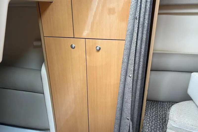 Slide: The Image of Interior of 2004 Maxum 3100 SE boat with wooden cabinet and patterned curtain. - 14