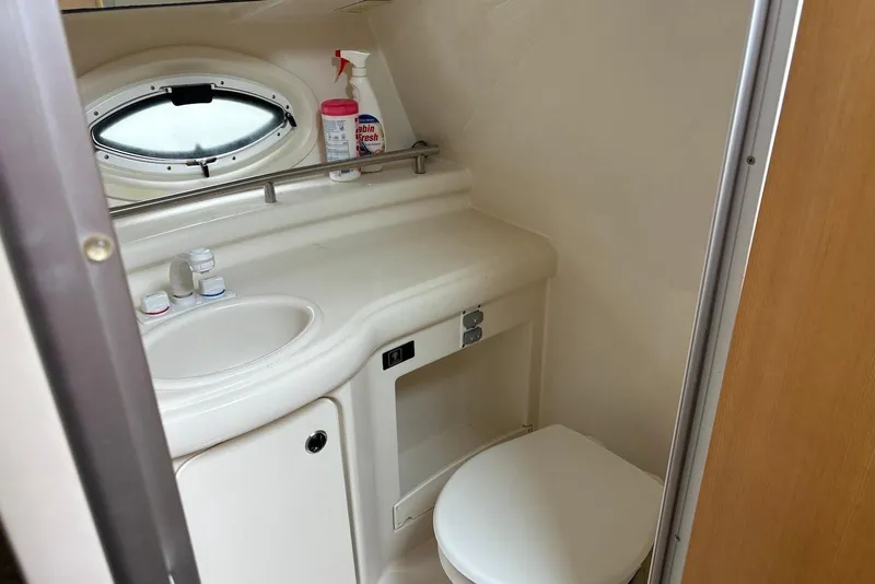 Slide: The Image of 2004 Maxum 3100 SE boat bathroom with sink, toilet, and porthole window. - 16