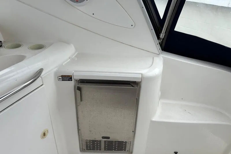 Slide: The Image of 2004 Maxum 3100 SE boat interior with compact fridge and cup holders. - 17