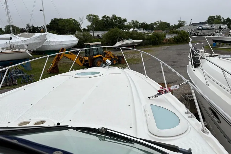 Slide: The Image of 2004 Maxum 3100 SE boat on land, surrounded by other boats and a tractor. - 18