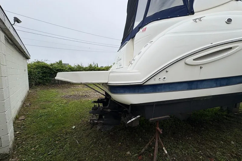Slide: The Image of 2004 Maxum 3100 SE boat on land, rear view, near a building. - 19