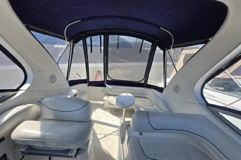 Slide: The Image of Interior of 2004 Maxum 3100 SE boat with white seating and blue canopy. - 4