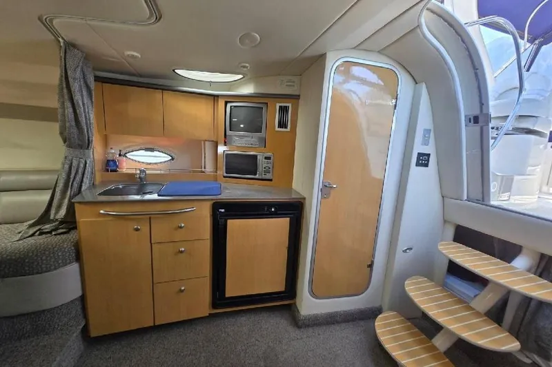 Slide: The Image of 2004 Maxum 3100 SE yacht interior with kitchenette, microwave, and compact fridge. - 6