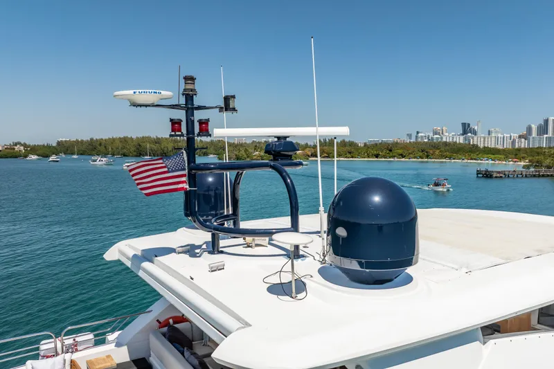 Slide: The Image of Sunseeker 34 Metre Yacht (2010) with radar equipment, American flag, and scenic coastal backdrop. - 12