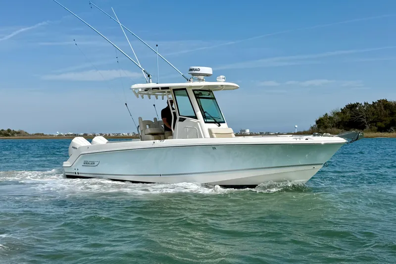 Slide: The Image of 2024 Boston Whaler 250 Outrage boat cruising on clear blue water. - 10