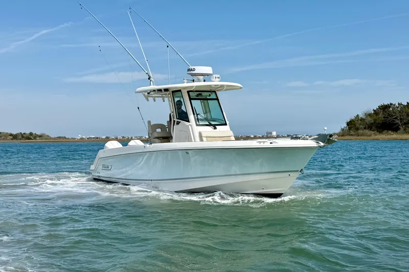 Slide: The Image of 2024 Boston Whaler 250 Outrage boat cruising on clear blue water. - 11