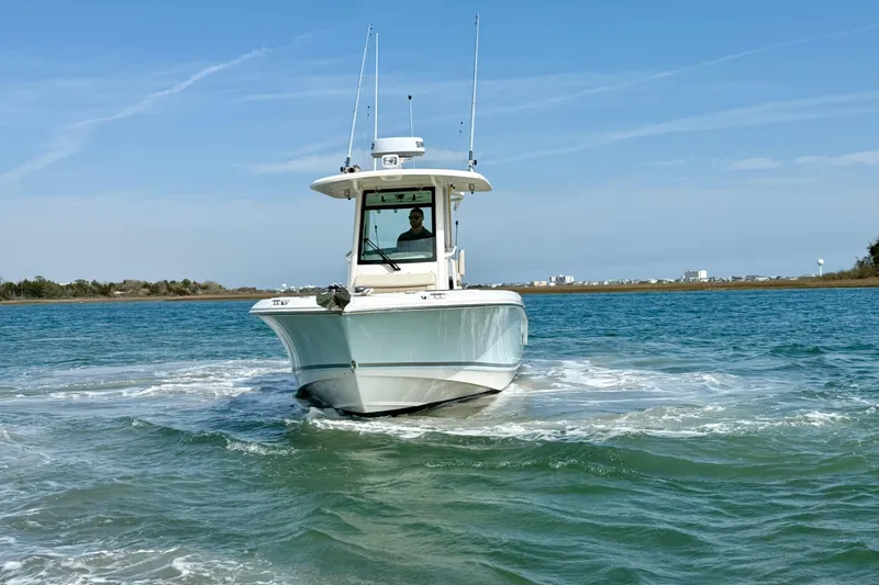 Slide: The Image of 2024 Boston Whaler 250 Outrage boat cruising on clear blue water. - 13