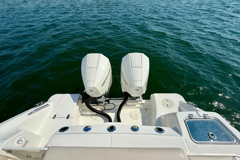 Slide: The Image of 2024 Boston Whaler 250 Outrage with dual Mercury outboard engines on open water. - 15