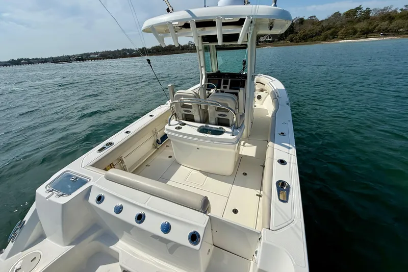 Slide: The Image of 2024 Boston Whaler 250 Outrage boat on calm water, showcasing spacious deck and seating. - 16