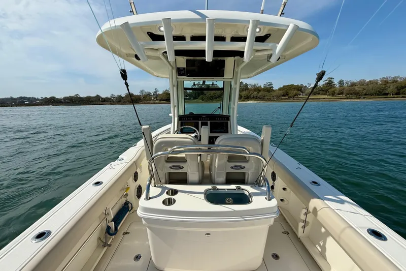 Slide: The Image of 2024 Boston Whaler 250 Outrage boat on water, featuring spacious deck and fishing equipment. - 18