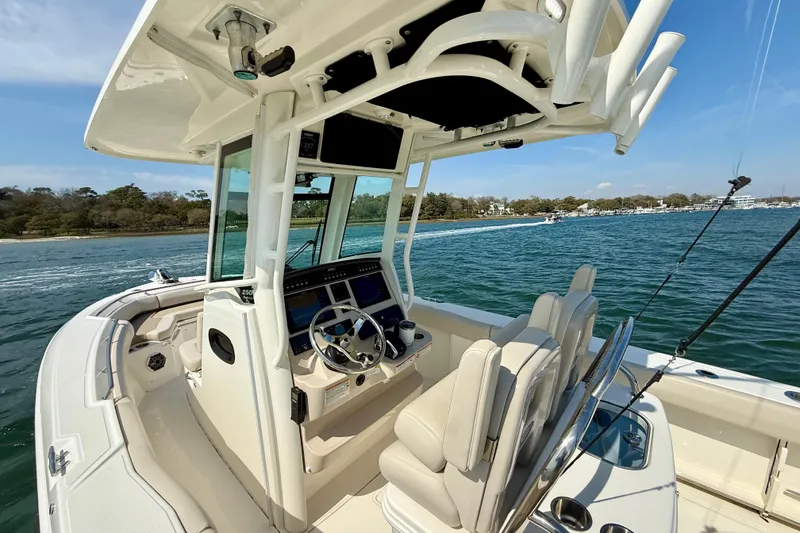Slide: The Image of 2024 Boston Whaler 250 Outrage boat interior with helm, seats, and ocean view. - 24