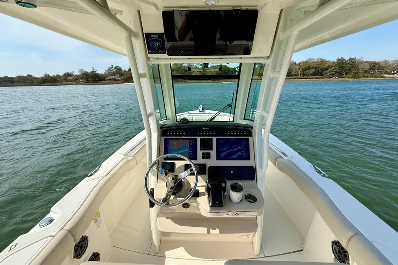 Slide: The Image of 2024 Boston Whaler 250 Outrage boat cockpit with advanced navigation system on calm water. - 25