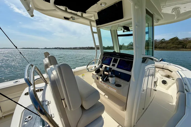 Slide: The Image of 2024 Boston Whaler 250 Outrage boat interior with modern helm and scenic water view. - 26