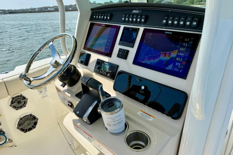 Slide: The Image of 2024 Boston Whaler 250 Outrage helm with advanced navigation displays and controls. - 27