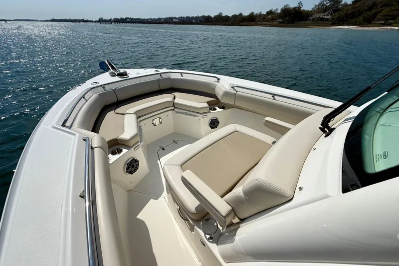 Slide: The Image of 2024 Boston Whaler 250 Outrage boat interior with cushioned seating on the water. - 32