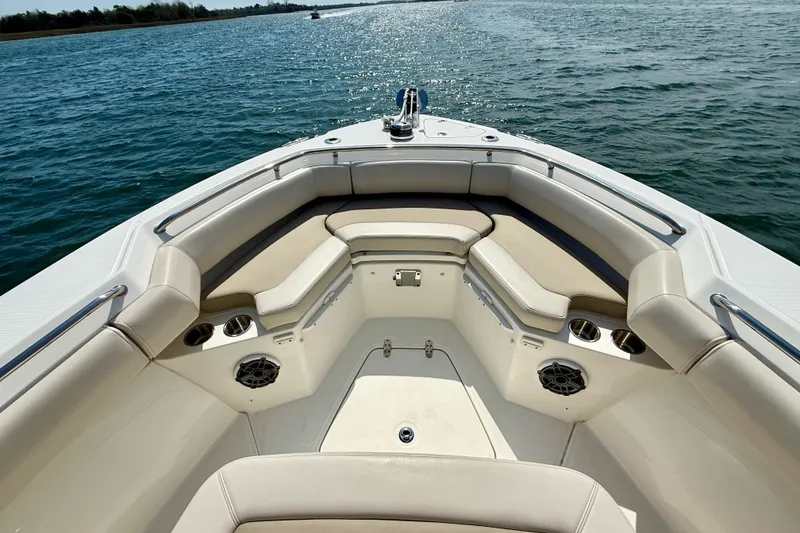 Slide: The Image of 2024 Boston Whaler 250 Outrage boat interior with cushioned seating and cup holders on the water. - 34