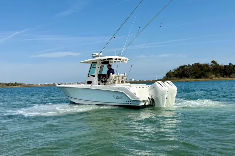 Slide: The Image of 2024 Boston Whaler 250 Outrage boat cruising on clear blue water. - 4