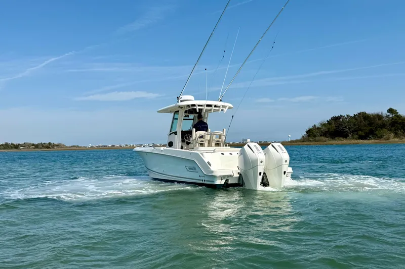 Slide: The Image of 2024 Boston Whaler 250 Outrage boat cruising on clear blue water. - 5