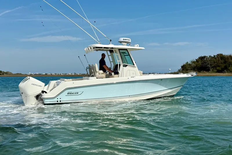 Slide: The Image of 2024 Boston Whaler 250 Outrage boat cruising on clear blue water. - 9