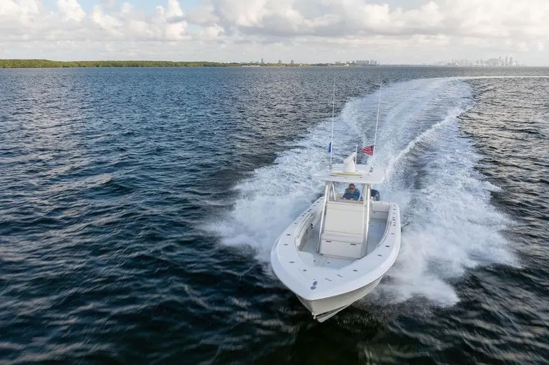 Slide: The Image of 2013 Contender 32 ST boat cruising on open water under cloudy sky. - 13