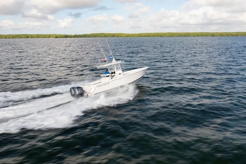 Slide: The Image of 2013 Contender 32 ST boat speeding on open water under a partly cloudy sky. - 14