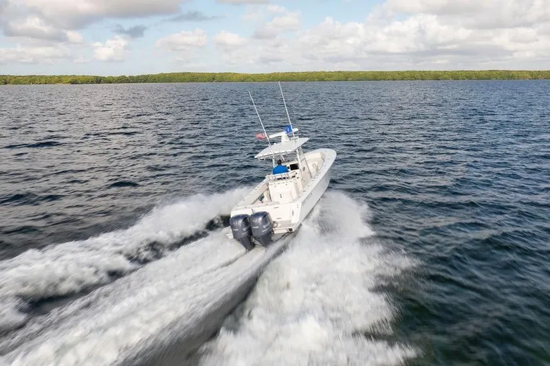 Slide: The Image of 2013 Contender 32 ST boat speeding on open water under a cloudy sky. - 15