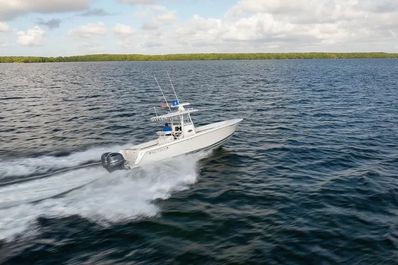 Slide: The Image of 2013 Contender 32 ST boat speeding on open water under a cloudy sky. - 16