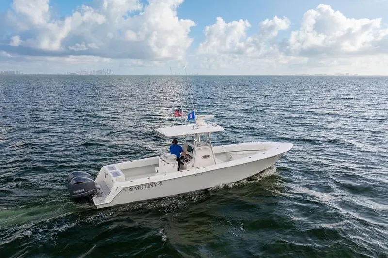 Slide: The Image of 2013 Contender 32 ST boat cruising on open water under a partly cloudy sky. - 19