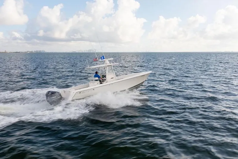 Slide: The Image of 2013 Contender 32 ST boat cruising on open water under a cloudy sky. - 20