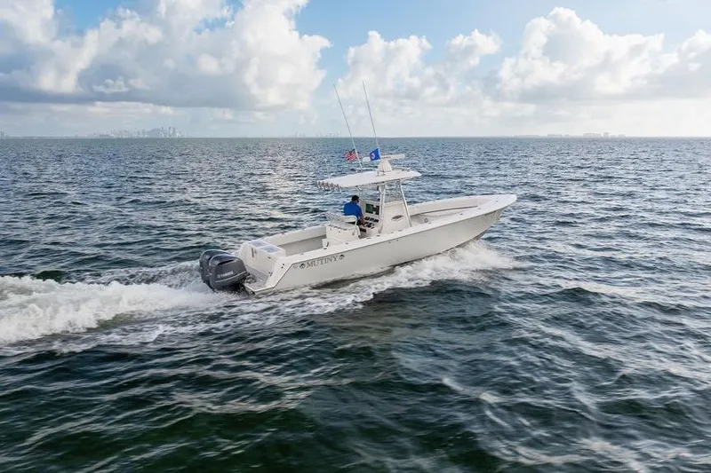 Slide: The Image of 2013 Contender 32 ST boat cruising on open water under a partly cloudy sky. - 21