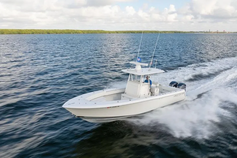 The Image of 2013 Contender 32 ST boat cruising on open water under a cloudy sky. - 3