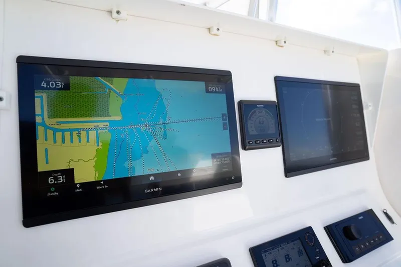 Slide: The Image of 2013 Contender 32 ST boat dashboard with Garmin navigation displays and controls. - 33
