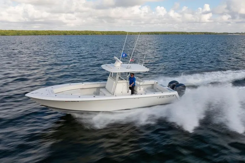 Slide: The Image of 2013 Contender 32 ST boat speeding on open water under a cloudy sky. - 5