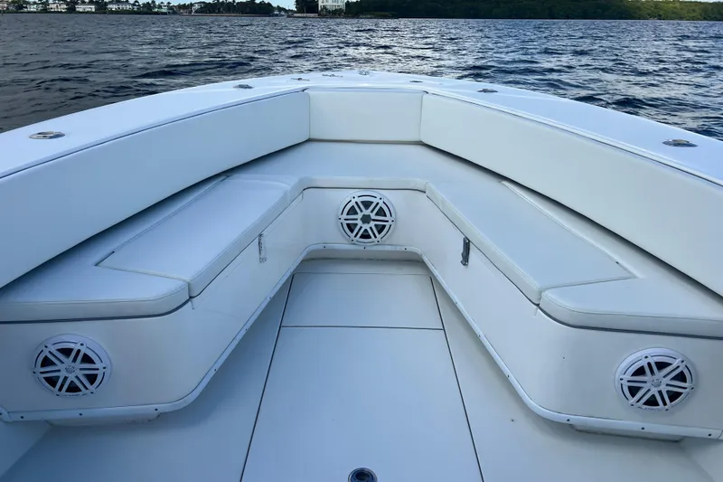 Slide: The Image of 2013 Contender 32 ST boat interior with cushioned seating and speakers on a calm water backdrop. - 62