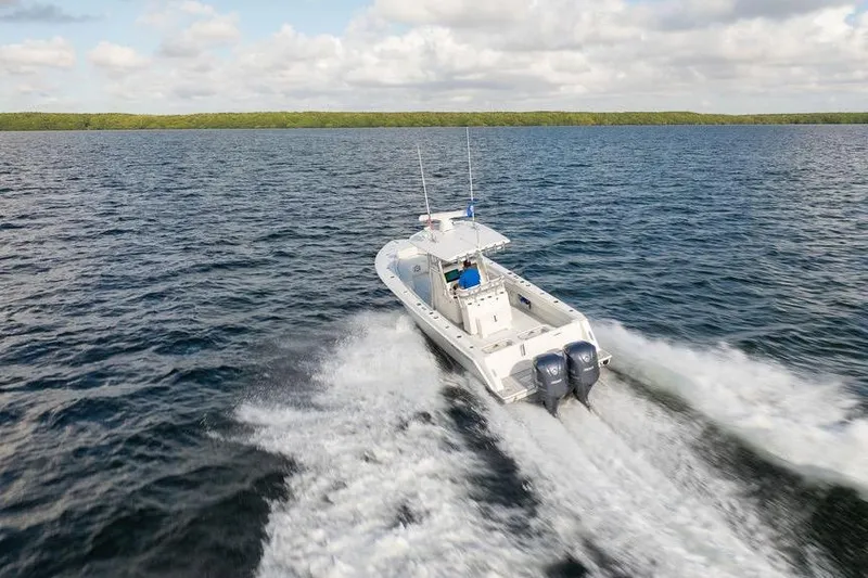Slide: The Image of 2013 Contender 32 ST boat cruising on open water under a cloudy sky. - 7