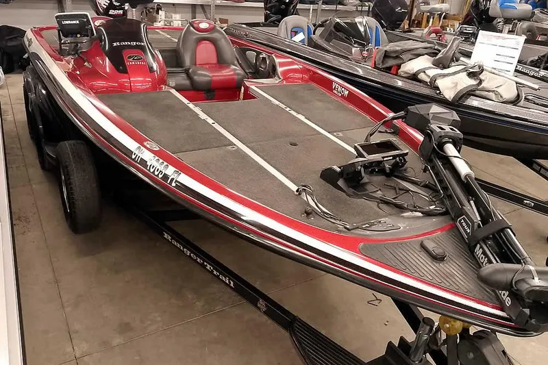 Slide: The Image of 2005 Ranger Z20 Comanche bass boat in showroom, featuring red and black design. - 42