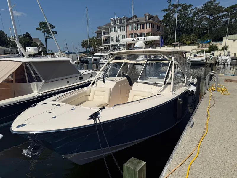 The Image of 2021 Grady-White Freedom 307 boat docked at marina with nearby buildings. - 0