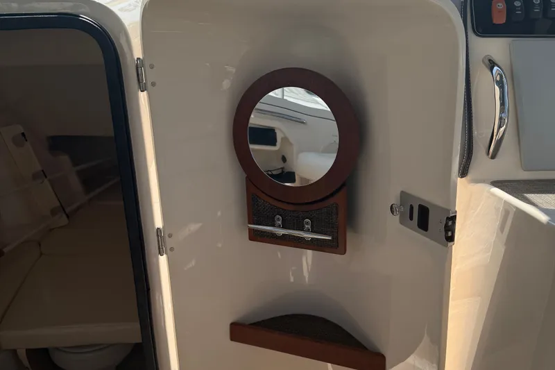 Slide: The Image of 2021 Grady-White Freedom 307 boat interior with mirror and storage compartment. - 11