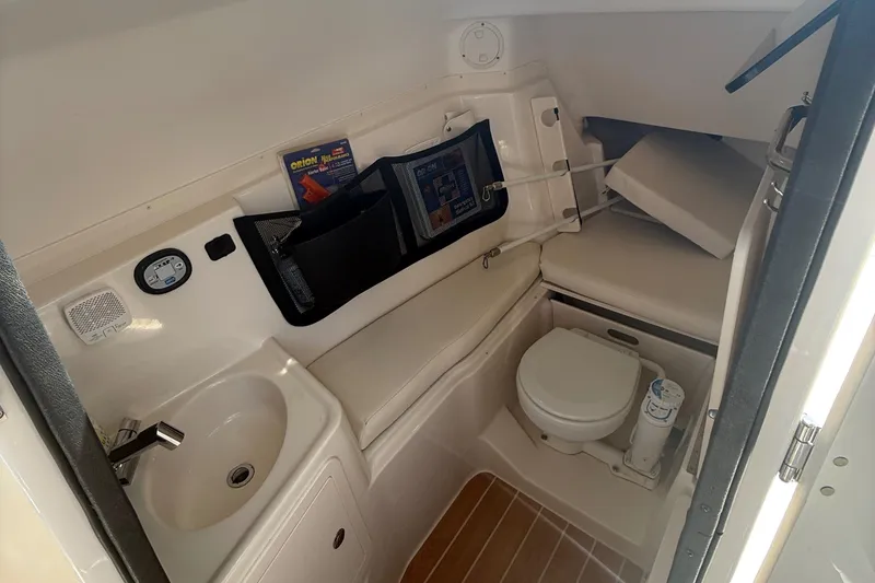 Slide: The Image of 2021 Grady-White Freedom 307 boat interior with sink, toilet, and storage compartments. - 13