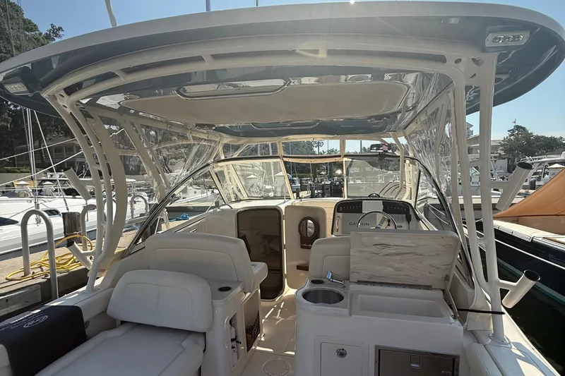 Slide: The Image of 2021 Grady-White Freedom 307 boat interior with seating and helm, docked at marina. - 15