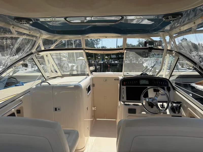 Slide: The Image of 2021 Grady-White Freedom 307 boat interior with helm, steering wheel, and seating. - 5