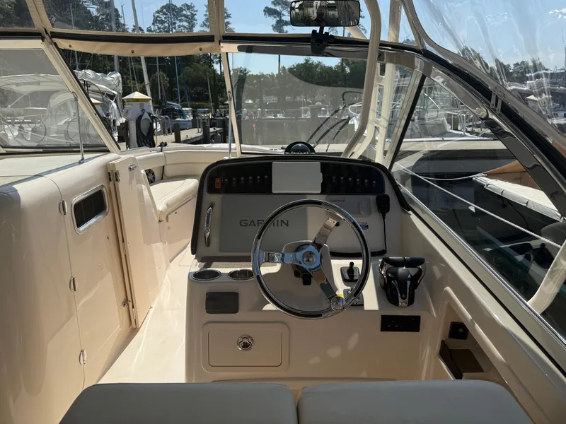Slide: The Image of 2021 Grady-White Freedom 307 boat cockpit with steering wheel and Garmin navigation system. - 7